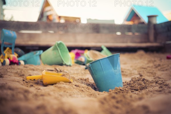 Children plastic toys in the sand box. Dirt bucket, selective focus