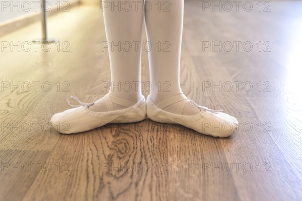 Child's legs of a girl in pointe shoes preparing for ballet classes