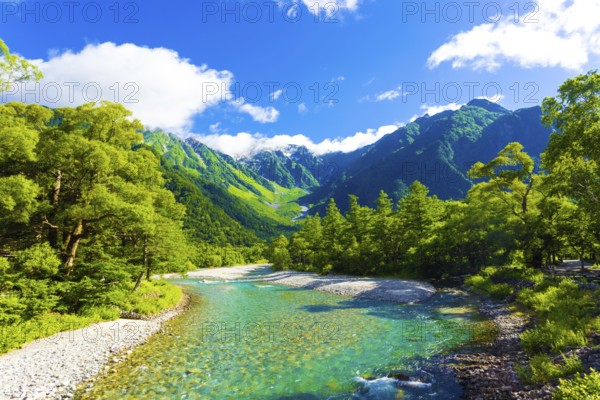 The pristine alpine water of Azusa River flowing in front of landscape view of Mount Hotaka-Dake on