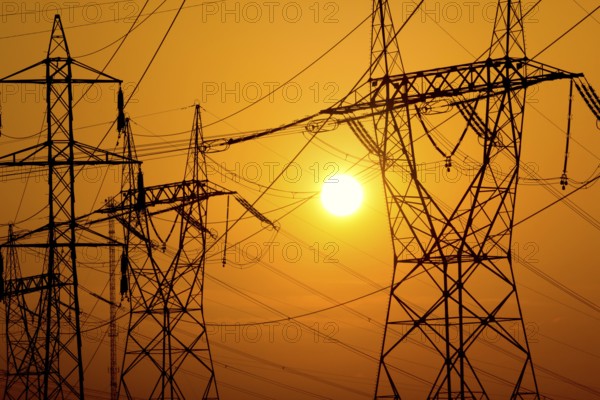 Transmission towers on sunset sky