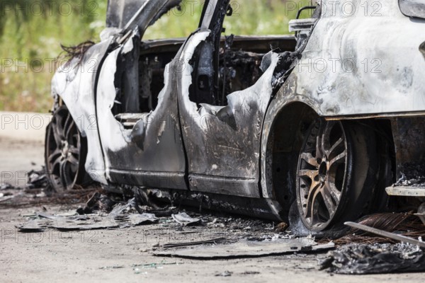 Road wreck accident or arson fire burnt wheel car vehicle junk