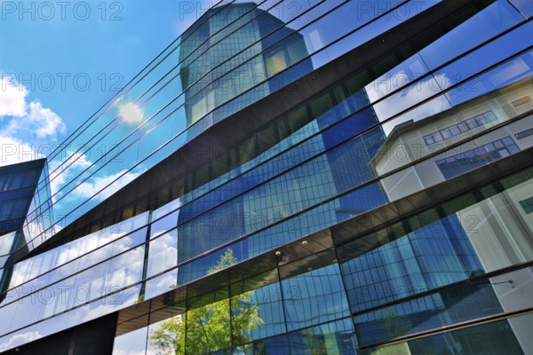 Modern glass façade of a high-rise building with reflections of sky and clouds, Prime Tower,