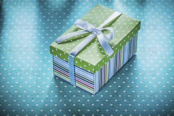 Wrapped gift on blue dotted tablecloth Holiday concept