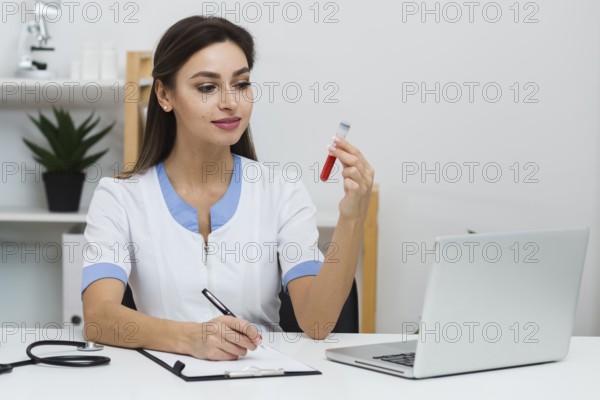 Smiling doctor looking blood sample