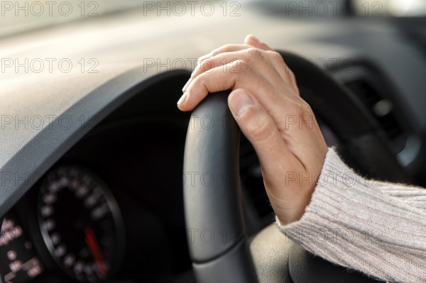 Side view woman her car holding steering wheel while driving
