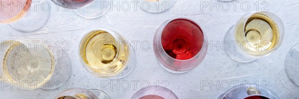 Wine glasses at a tasting panorama. Rose, red, and white wine, drinks, overhead flat lay shot. An