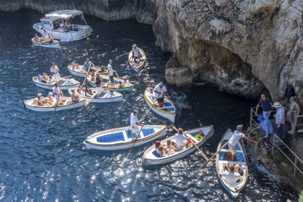 Italy, Gulf of Naples. Island of Capri, Blue Grotto. Boats with tourists in front of the entrance