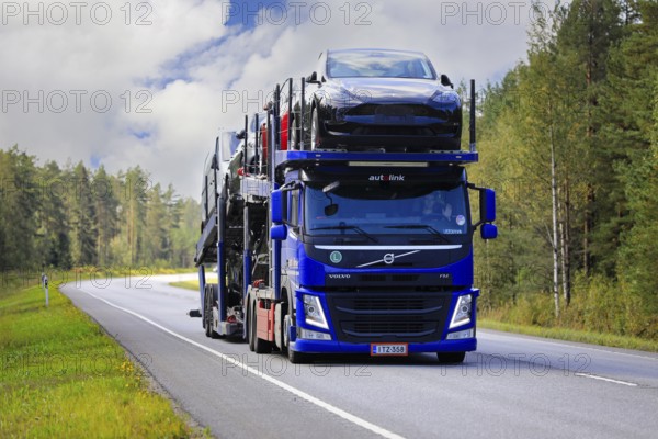 Blue Volvo FM car carrier Autolink Oy hauls Tesla and other new cars on road 25 from Hanko Port to