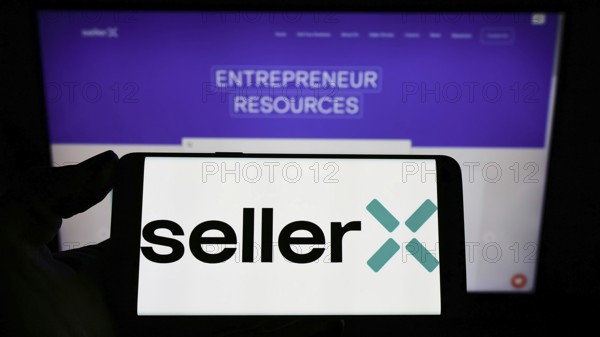 Stuttgart, Germany, 05-08-2022: Person holding mobile phone with logo of e-commerce company SellerX
