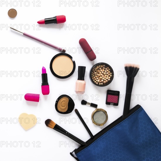 Different cosmetics scattered from beauty bag table