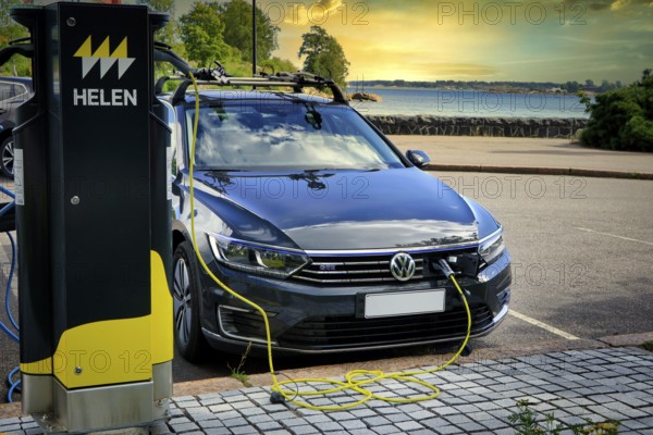 Volkswagen Passat GTE plug-in hybrid electric car charging battery at seaside Helen Charging Point.