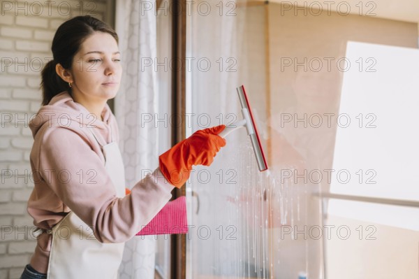 Side view woman cleaning window