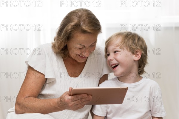 Happy kid grandma with tablet