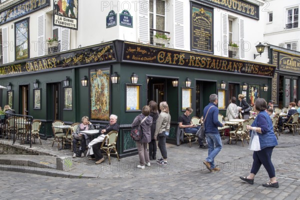 Paris, France, May 12, 2017: The streets of Montmartre district with people sitting in cafes and