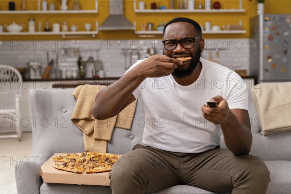 Man watching tv eating pizza