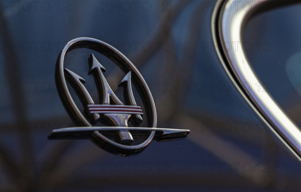 A close-up picture of the Maserati logo on the back of a vehicle