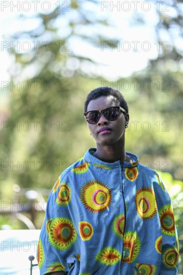 Young adult afro hair diverse black model pose outdoors in african print attire wear sunglasses