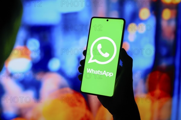 In this photo illustration, the WhatsApp logo is displayed on a smartphone screen