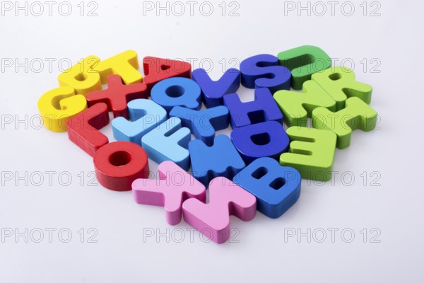 Colorful letter blocks shape heart on white background