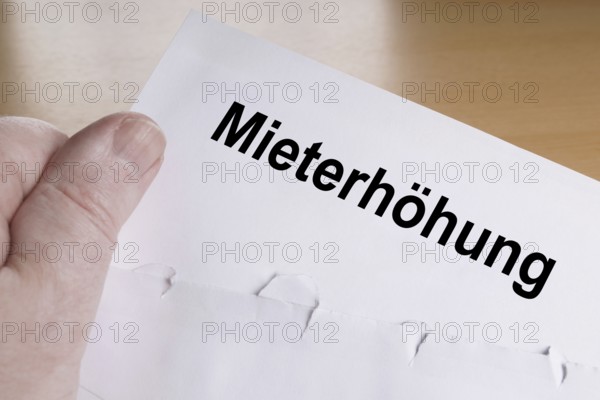 Mieterhöhung is German for rent increase, hand holding letter