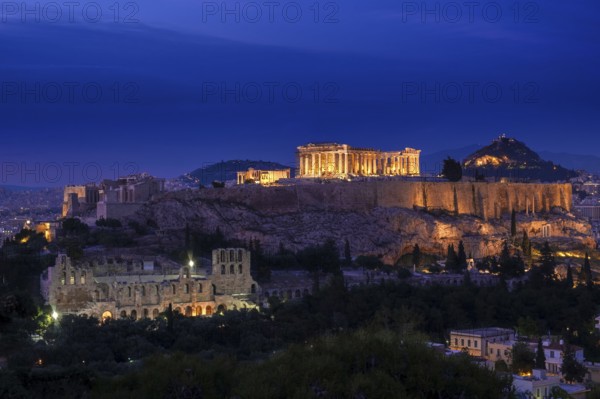 Iconic view of Acropolis hill in Athens, Greece at night. Delicate lights of Parthenon and Odeon