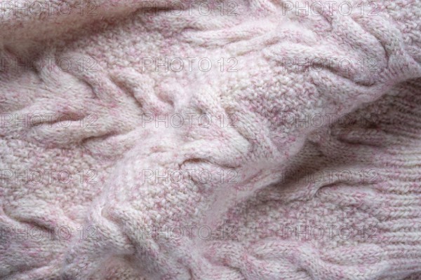 Soft folds of a warm pink knitted woolen pullover to be used as background