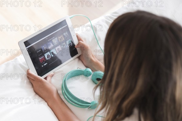 Young woman holding tablet with spotify app. High resolution photo