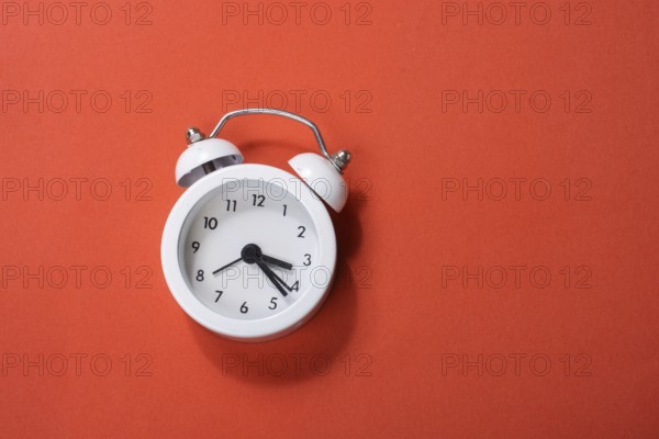Alarm clock on colorful background in view