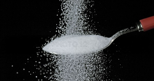 White Sugar falling against Black Background