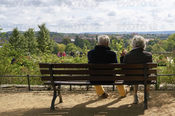 Elderly pensioner couple sitting on a bench and enjoying the view