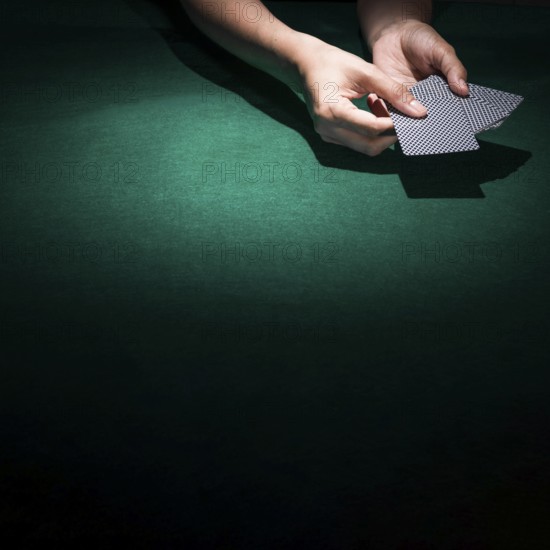 Person hand s holding poker card