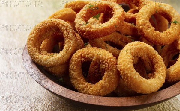 Deep fried onion rings, appetizer, with tomato sauce, on a wooden plate, without people, favorite