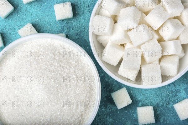 White sugar in bowls on blue textured background