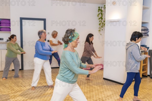 Mature women in a Qi gong class choreographing the exercises moving coordinated