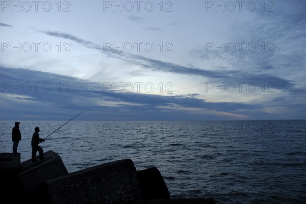 Silhouettes of two people at sunset, Ventspils, Latvia, Europe