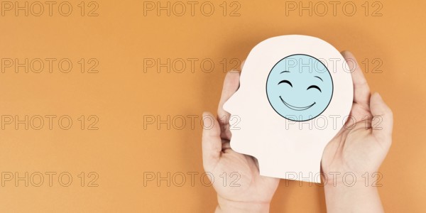 Holding a head with a happy smiling face, mental health concept, positive mindset, support and