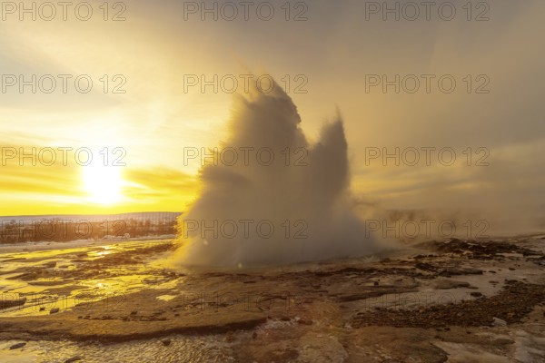 Beautiful eruption of the Strokkur Geyser at sunrise. Iceland's frozen winter is very cold