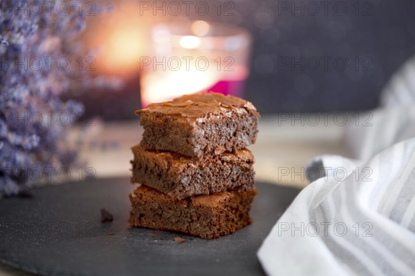 Homemade dark chocolate fudge brownies cake stacked on stone plate with copy space. Lavender