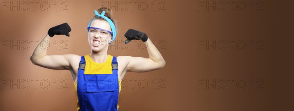Panoramic beautiful caucasian woman repairman worker with blue eyes in uniform showing arm muscles,
