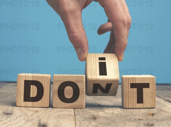 Hand of a businessman with wooden blocks and the words Do it ! Motivational concept