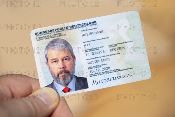 Hand holding an identity card of the Federal Republic of Germany with a businessman around 50 years