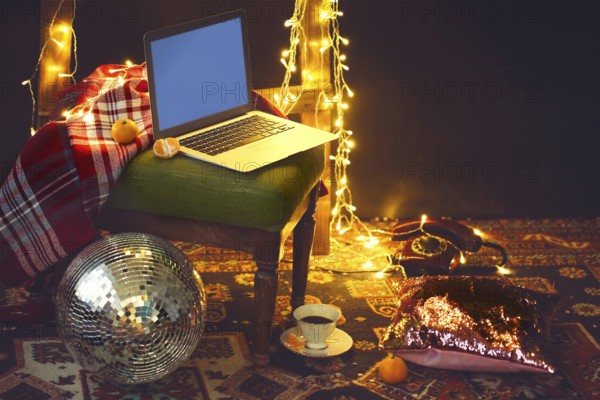 New Year's eve or Christmas still life with retro phone, disco ball, notebook, coffee, candle and