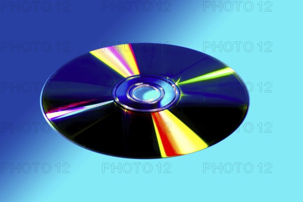 CD DVD disk with colorful reflexion over vivid blue background