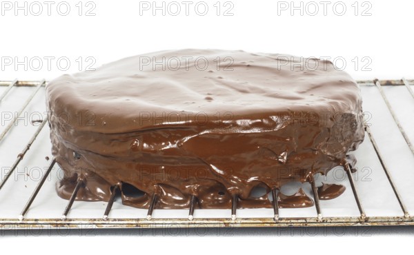 Chocolate icing dripping off from freshly made sacher torte cake