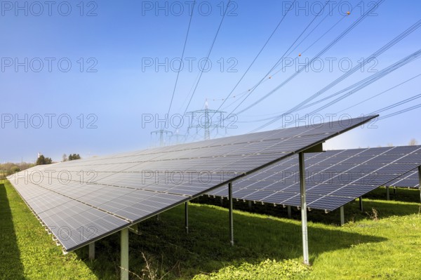 Solar park with high-voltage pylons