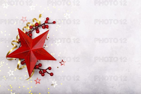 Red star berries Christmas decorations on grey stone background flat lay copy space