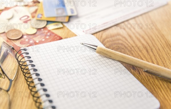 Conceptual image for planing and organizing the financials with a graph notepad, pen, eyeglasses