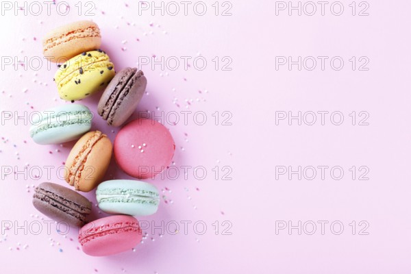 Colorful french macarons on pink background traditioanal desert in France