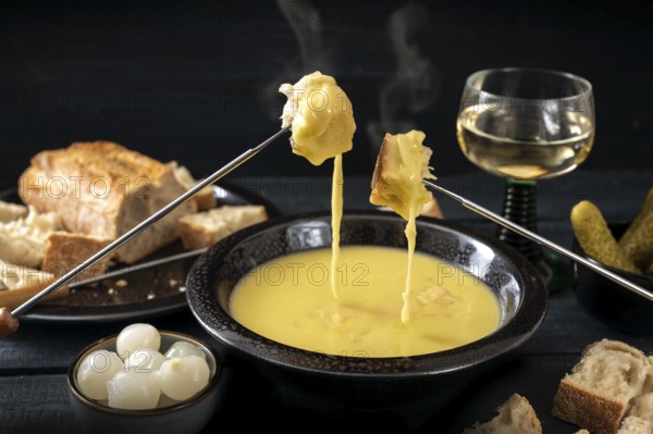 Swiss cheese fondue with bread, pickles and wine, the festive dinner is often served at new year,
