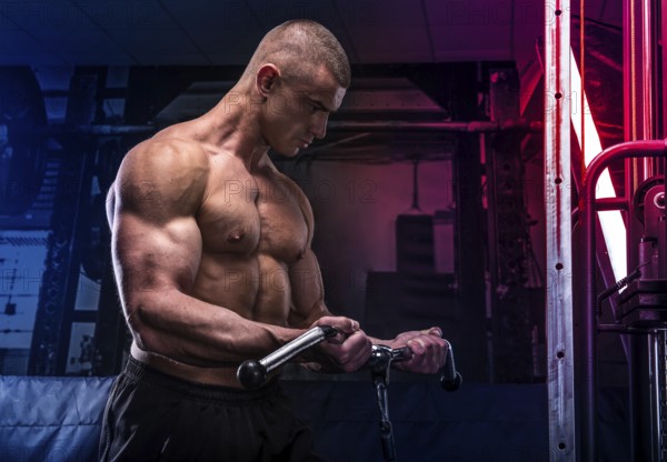 Young bodybuilder training in a gym, lifting hard weigh
